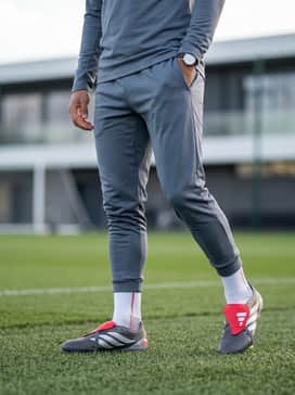 A technical training look consisting of a black moisture-wicking quarter-zip top and tapered athletic joggers in slate grey for a streamlined, professional appearance during drills.