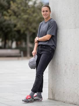 A modern 'bloke-core' street outfit pairing a vintage-inspired oversized football jersey, slim-fit dark denim jeans, and a sleek baseball cap for a casual sports-fan aesthetic.