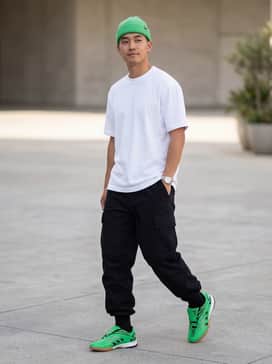 Black oversized cargo pants paired with a crisp white heavyweight cotton tee and a matching green beanie to echo the sneaker's vibrant hue.