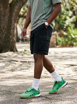 Black utility shorts styled with high-cut white crew socks and a graphic t-shirt that features neon green accents to tie the whole aesthetic together.