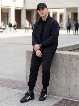 Pro Model Adv Shoes – A clean athletic outfit with slim-fit black joggers, a matching zip-up track top, and a white baseball cap for a cohesive monochromatic vibe.