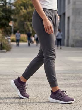 Pureboost 23 Shoes – Slim-fit charcoal joggers worn with a tucked-in oversized white tee and a distressed denim jacket for a stylish weekend vibe.