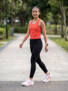 High-performance black compression leggings paired with a solar red moisture-wicking racerback tank and a thin white running headband to mirror the shoe colors.