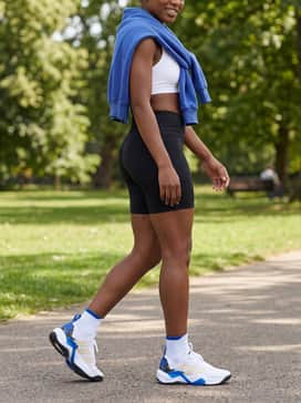Rapidmove Adv 2 Training Shoes – Black biker shorts combined with a simple white sports bra and an oversized cobalt blue sweatshirt draped over the shoulders for an effortless weekend vibe.