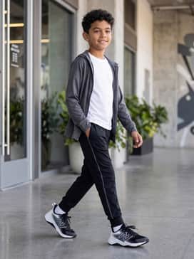 A casual school outfit consisting of slim-fit dark denim jeans, a light grey heathered t-shirt, and a classic navy zip-front hoodie.
