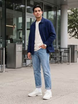 Distressed straight-leg light-wash denim, a vintage-inspired graphic t-shirt, and a navy chore jacket for a rugged but clean street aesthetic.