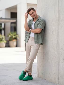 Off-white linen drawstring shorts combined with a sage green short-sleeve button-down shirt layered over a white ribbed tank top for a breezy summer aesthetic.