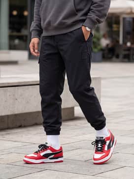 Style with black techwear joggers and a charcoal grey oversized hoodie to let the vibrant red and white of the shoes stand out as a statement piece.