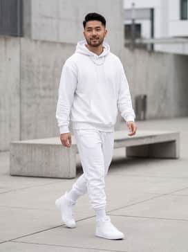 Rebound V6 Wide Mens Sneakers – A clean monochromatic streetwear look featuring white tapered joggers, an oversized white graphic hoodie, and a silver chain necklace.