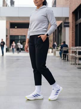 Black tapered tech-fleece joggers, a light grey fitted hoodie, and white crew socks for a clean, athletic aesthetic.