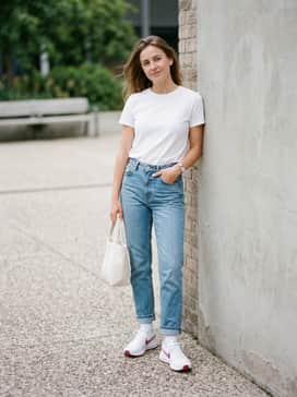 Straight-leg light wash denim jeans with a rolled cuff and a simple white tucked-in tee for a relaxed weekend style.