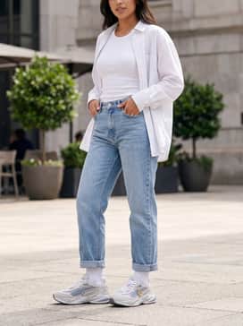 Rs Surge Nyc Womens Sneakers – Straight-leg light-wash denim jeans with a raw hem, a tucked-in white ribbed tank top, and an unbuttoned oversized pinstripe shirt.