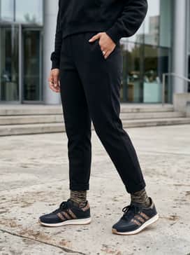 Tapered black joggers and a matching cropped hoodie, creating a sleek monochromatic base that highlights the leopard print details.