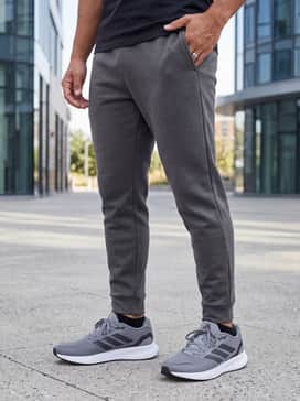 Casual Athleisure: Navy blue tapered joggers matched with a light gray fleece hoodie and a minimalist baseball cap for a relaxed weekend vibe.