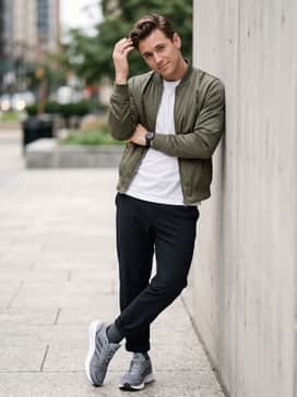 Urban Utility: Slim-fit black athletic chinos worn with a crisp white crewneck t-shirt and an olive green bomber jacket for a modern street style.
