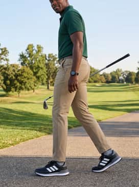 S2g 26 Spikeless Golf Shoes – A professional-yet-sporty pairing of khaki golf trousers, a deep forest green polo shirt, and a sleek black sports watch.