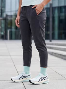 A streetwear-inspired ensemble with tapered black tech-fleece joggers, a grey oversized boxy tee, and a matching mint-colored baseball cap.