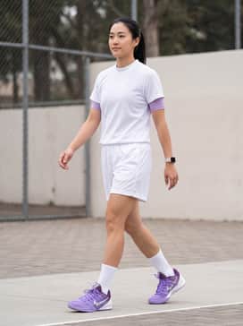 Sabrina 3 Flowers – A full performance basketball kit featuring white mesh shorts, a lavender compression top, and high-performance white crew socks to highlight the shoe's vibrant tones.