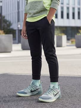 Black tapered joggers paired with a lime green graphic hoodie to pull out the bright tones of the sneaker's outsole.