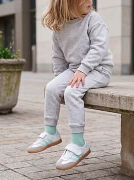 Light grey jersey joggers paired with a matching mint-striped zip-up hoodie to reflect the shoe's athletic heritage.