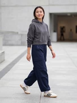 Pair with oversized navy blue wide-leg cargo pants, a cropped charcoal grey hoodie, and a silver chain necklace for a balanced streetwear look.