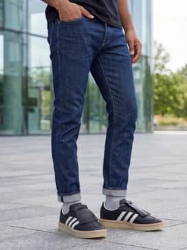 Samba Lux Shoes – Slim-fit indigo selvedge denim with a single cuff, a light blue oxford button-down shirt, and a tan suede bomber jacket to complement the shoe's gum-colored sole.