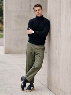 Samba Lux Shoes – Wide-leg olive green chinos, a black turtleneck sweater, and a minimalist silver watch, allowing the unique kiltie fringe of the shoe to be the focal point of the outfit.