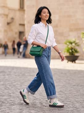 Pair these sneakers with high-waisted wide-leg denim in a medium wash, a tucked-in oversized white button-down shirt, and a structured emerald green handbag to echo the shoe's accent color.