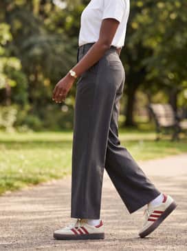 Sambae Shoes – Charcoal grey wide-leg tailored trousers with a crisp tucked-in white t-shirt and a structured navy blazer for a polished smart-casual office outfit.