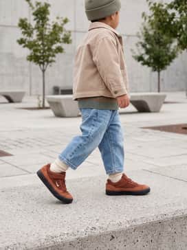 A classic skate-inspired look featuring relaxed-fit light wash denim jeans, a vintage-style graphic t-shirt, and a neutral-colored beanie for a cool, effortless vibe.