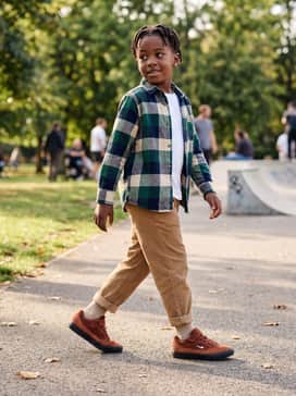 Sb Malor – A smart-casual weekend look pairing tan corduroy trousers with a buffalo check flannel shirt layered over a simple white tee.