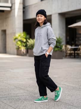 A pair of loose-fit black cargo pants paired with a heather grey oversized graphic hoodie and a black knit beanie for a classic skate park aesthetic.
