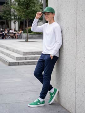 Tapered navy blue joggers combined with a white long-sleeve breathable performance top and a matching green snapback hat for a coordinated sporty vibe.