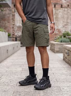 Seasons Voyage Nitro 3 Mens Running Shoes – A summer hiking outfit consisting of olive green ripstop cargo shorts, a breathable mesh tank top, and a wide-brimmed sun hat.