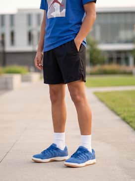 Black mesh athletic shorts teamed with a matching royal blue graphic t-shirt and white crew socks for a coordinated sporty outfit perfect for the park.