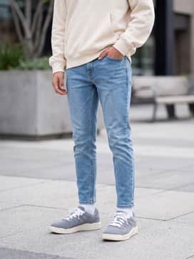 Session – Light wash tapered denim jeans paired with an oversized cream-colored hoodie to complement the vintage-style midsole.