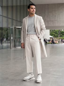 Sgendo Trail Shoes – Bone-colored wide-leg tailored trousers, a tucked-in light grey cashmere crewneck sweater, and a matching long wool overcoat to emphasize the architectural silhouette.