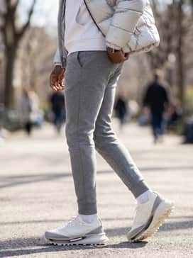 Sgendo Trail Shoes – Slim-fit grey tech-fleece joggers, a cropped white hoodie, and a silver metallic puffer jacket to lean into the futuristic, space-age aesthetic of the hollowed-out sole.