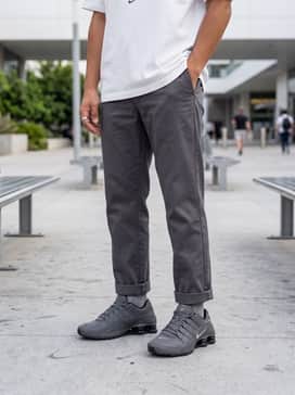Slim-fit charcoal denim jeans and an oversized heavyweight white graphic tee with minimalist silver jewelry.