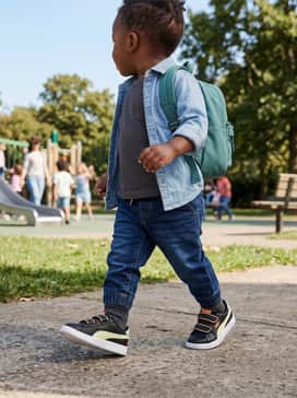 A sporty striped jersey dress worn with black leggings and a light denim jacket for a trendy and versatile everyday ensemble.