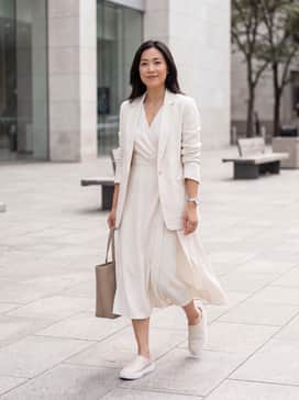 Soft 60 – A pair of high-waisted beige linen trousers paired with a tucked-in white silk camisole and a matching linen blazer for a sophisticated monochromatic look.
