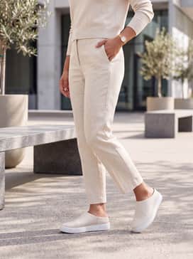 Soft 60 – Cropped light-wash straight-leg jeans combined with a crisp white button-up shirt and a tan trench coat for an effortlessly chic city outfit.