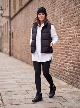 Soft 7 Tred – Premium black leggings, a crisp white long-line button-up shirt, and a matte black quilted puffer vest for a modern athletic-casual vibe.