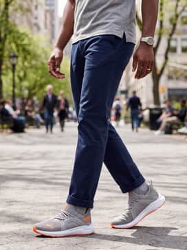 Straight-leg navy chino pants paired with a grey heathered polo shirt for a polished yet comfortable athleisure ensemble suitable for casual office days or weekend errands.