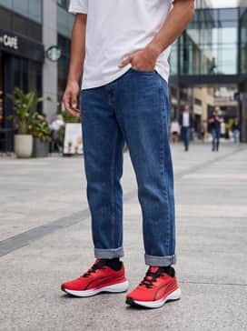 Slim-fit indigo denim jeans cuffed at the ankle, a plain white crew-neck t-shirt, and an unbuttoned black flannel shirt for a classic, effortless casual weekend style.