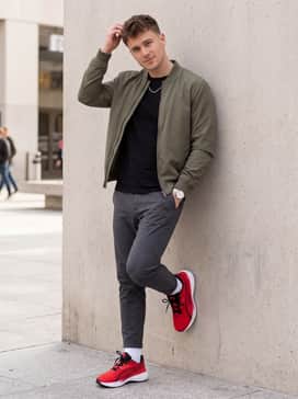 Olive green cargo pants matched with an oversized black graphic t-shirt and a silver chain necklace to lean into a bold, urban streetwear aesthetic.