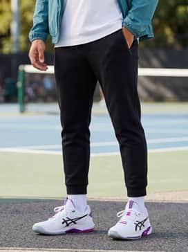 Solution Speed Ff 4 Clay – A sleek streetwear look consisting of tapered black tech-fleece joggers, a minimalist white oversized tee, and a lightweight teal windbreaker.