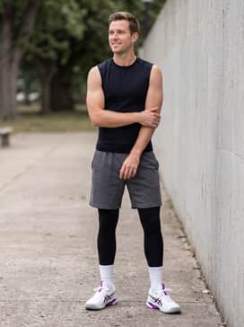 Solution Speed Ff 4 Clay – A relaxed gym outfit with charcoal grey jersey sweatshorts, a sleeveless black compression shirt, and high-performance white crew socks.