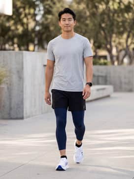 A performance-ready ensemble featuring navy compression tights under black 5-inch running shorts and a light grey moisture-wicking tech tee.