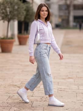 Distressed light-wash baggy jeans, a cropped zip-up hoodie in a pastel shade, and a small silver metallic shoulder bag to echo the anodized finish.